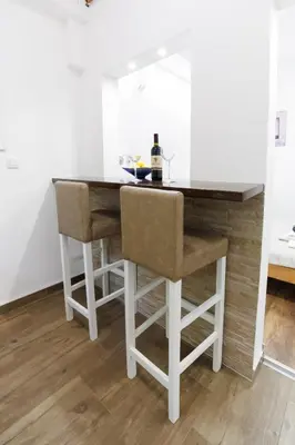 a kitchen with a table and two bar stools at Vila Jevtic studio 4 in Soko Banja