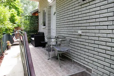 a patio with a table and chairs against a brick wall at Vila Jevtic studio 4 in Soko Banja