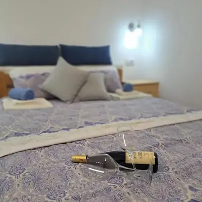 a bottle of wine laying on a bed at Vila Jevtic studio 4 in Soko Banja