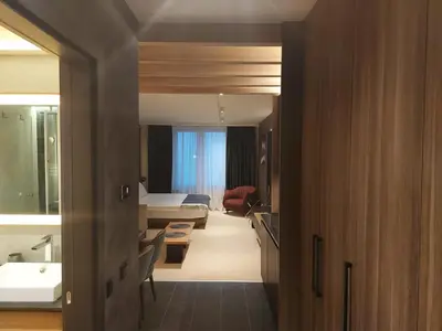 a hotel room with a bedroom and a bathroom at Woodside Apartments Kopaonik centar in Kopaonik