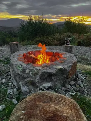 a fire pit in a field with a sunset in the background at Villa Monteverde Goč in Stanišinci