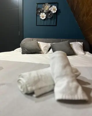 a bed with white sheets and pillows on it at Villa Monteverde Goč in Stanišinci