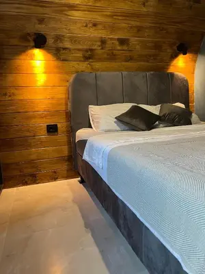 a large bed in a room with wooden walls at Villa Monteverde Goč in Stanišinci