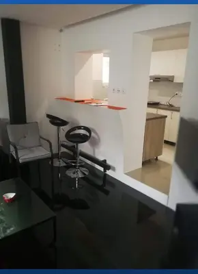 a room with a table and a chair and a kitchen at Apartman Sokobanja in Soko Banja
