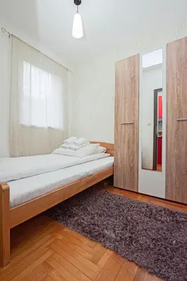 a bedroom with a bed and a cabinet and a rug at Apartmancic Stancic in Kopaonik