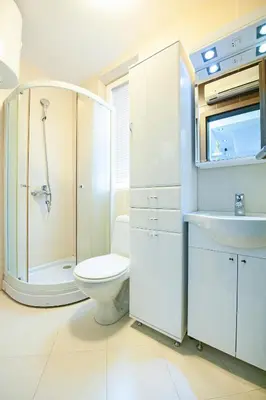 a white bathroom with a toilet and a sink at Apartmancic Stancic in Kopaonik