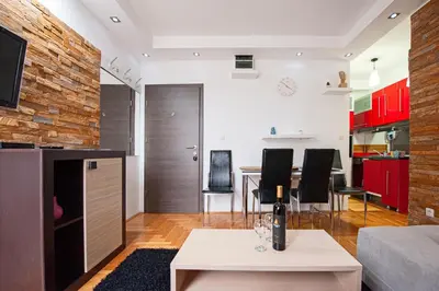 a living room and kitchen with red cabinets at Apartmancic Stancic in Kopaonik