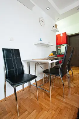 a dining room with black chairs and a table at Apartmancic Stancic in Kopaonik