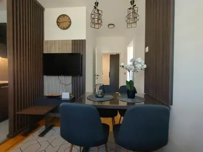 a dining room with a table and blue chairs at Apartman Novak Sokobanja in Soko Banja