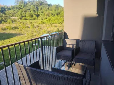 two chairs and a table on a balcony with a view at Apartman Novak Sokobanja in Soko Banja