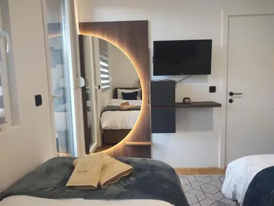 a room with a mirror and a bed and a tv at Apartman Novak Sokobanja in Soko Banja