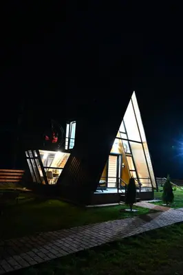 a small house with a triangular roof at night at Gočki Raj in Goč