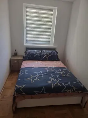 a small bedroom with a bed with a window at Apartman Nika Vb in Vrnjačka Banja