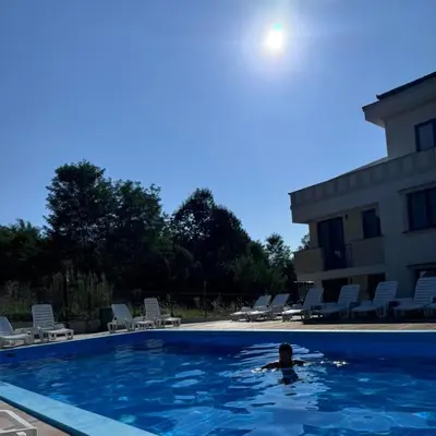 a person swimming in a swimming pool next to a building at Apartman Nika Vb in Vrnjačka Banja