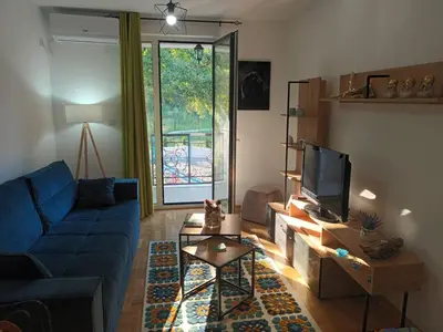 a living room with a blue couch and a tv at Apartman Nika Vb in Vrnjačka Banja