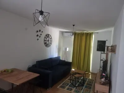 a living room with a blue couch and a table at Apartman Nika Vb in Vrnjačka Banja