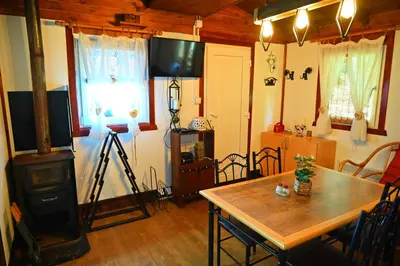a living room with a table and a television in it at Gocki raj 2 in Goč
