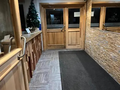 a hallway with wooden doors and a christmas tree at Vila Zvončica, apartman Puzović 22 in Kopaonik