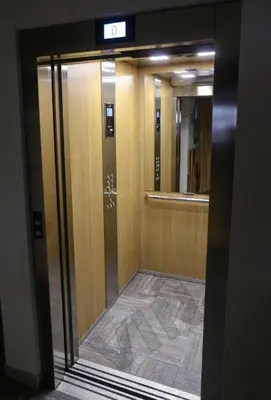 a glass door of a elevator with a tile floor at Vila Zvončica, apartman Puzović 22 in Kopaonik