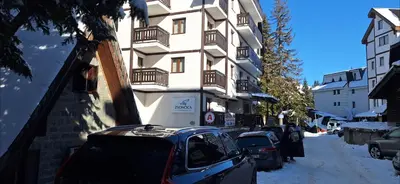 a car parked in front of a building in the snow at Vila Zvončica, apartman Puzović 22 in Kopaonik