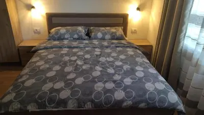 a bed with a blue comforter and two pillows at Alđo in Soko Banja