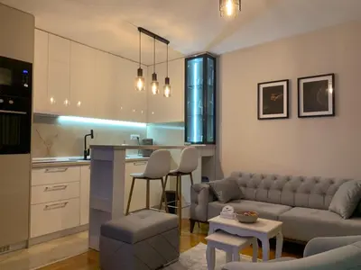 a living room and kitchen with a couch and a table at Urban Apartman-privatan parking- in Kraljevo