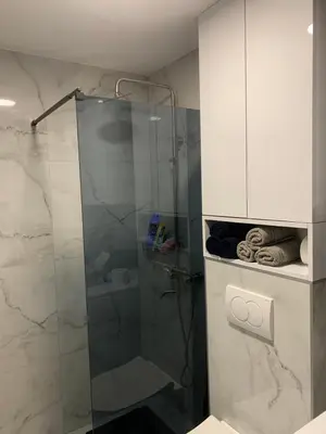 a bathroom with a shower with a glass door at Urban Apartman-privatan parking- in Kraljevo