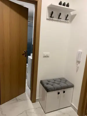 a bathroom with a stool in front of a door at Urban Apartman-privatan parking- in Kraljevo