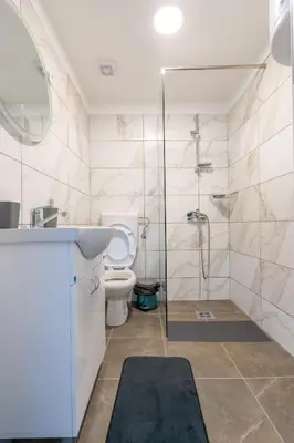 a bathroom with a toilet and a glass shower at Aleks apartmani in Knjazevac.