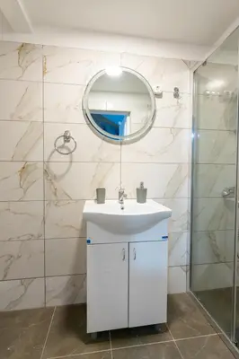 a bathroom with a white sink and a mirror at Aleks apartmani in Knjazevac.