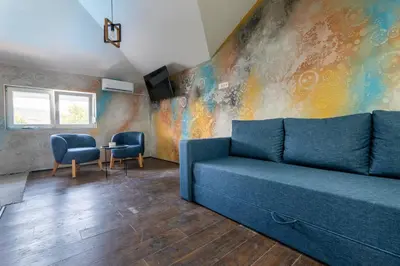 a living room with a blue couch and a table at Aleks apartmani in Knjazevac.