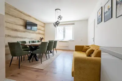 a living room with a couch and a table and chairs at Aleks apartmani in Knjazevac.