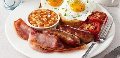 a plate of breakfast food with eggs sausage beans and toast at HOTEL Crystal Lights in Pirot