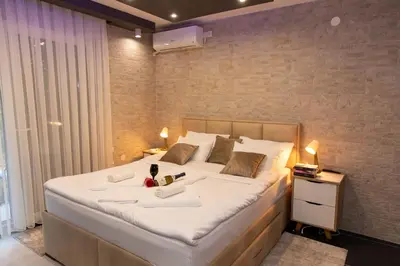 a large white bed with a stuffed animal on it at Art Lux apartman in Kruševac