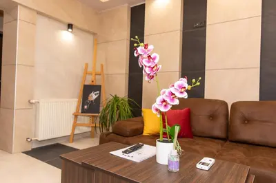 a living room with a couch and a table with flowers at Art Lux apartman in Kruševac