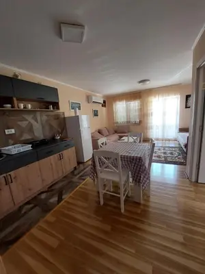 a living room with a table and a kitchen and a living room at Dukat 1 in Soko Banja
