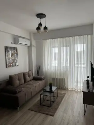 a living room with a brown couch and a table at Aqua apartman 45-2 in Jagodina