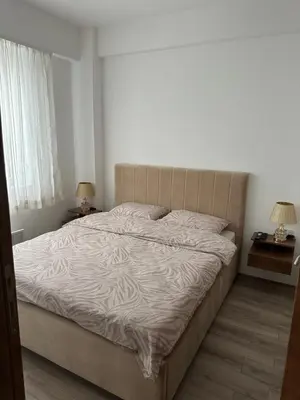 a large bed in a bedroom with two lamps on tables at Aqua apartman 45-2 in Jagodina