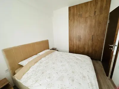 a bedroom with a bed and a wooden cabinet at Aqua apartman 45-2 in Jagodina