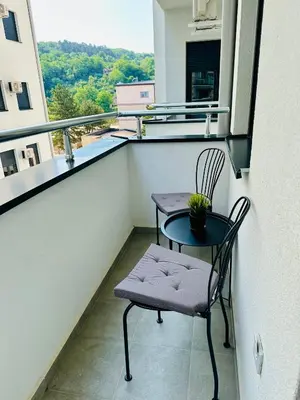 a balcony with a chair and a table and a window at Aqua apartman 45-2 in Jagodina