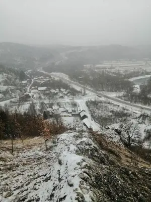 a snow covered hill with a road in the distance at Seosko turisticko domacinstvo Nikolic-Zivkovic selo Ljubatovica in Čiflik