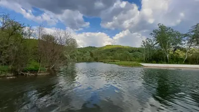 a view of a river with trees and clouds in the sky at Seosko turisticko domacinstvo Nikolic-Zivkovic selo Ljubatovica in Čiflik