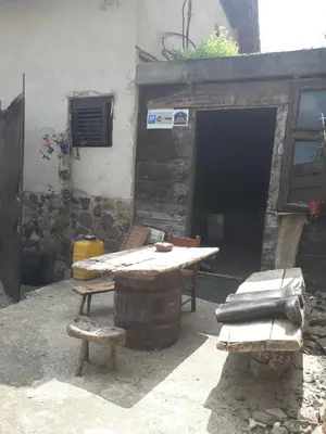 a picnic table and benches in front of a building at Seosko turisticko domacinstvo Nikolic-Zivkovic selo Ljubatovica in Čiflik