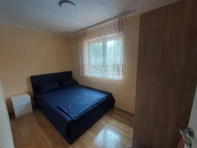 a bedroom with a blue bed and a window at Dukat 2 in Soko Banja