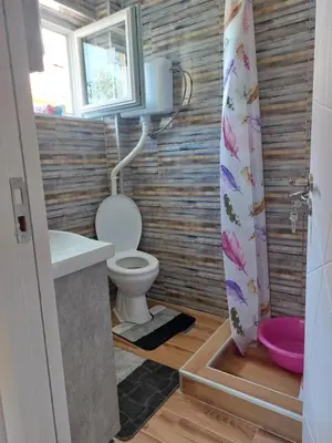 a bathroom with a toilet and a sink and a window at Dukat 2 in Soko Banja