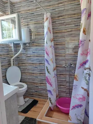 a bathroom with a toilet and a shower curtain at Dukat 2 in Soko Banja