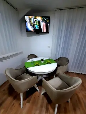 a dining room with a table and chairs and a television at Apartman Taša Vrnjačka Banja in Vrnjci