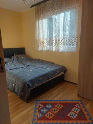 a bedroom with a bed and a window with a rug at Dukat 3 in Soko Banja