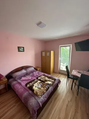a bedroom with a bed and a table and a window at Apartments Božinović in Soko Banja