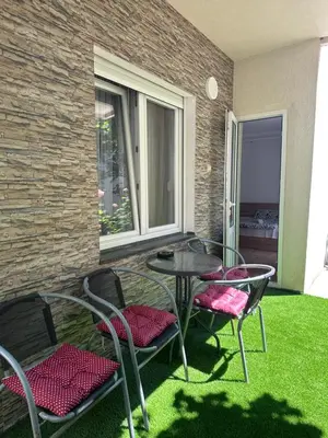 a patio with a table and chairs on the grass at Apartments Božinović in Soko Banja